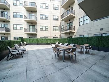 A patio with a table and chairs is in front of a building.